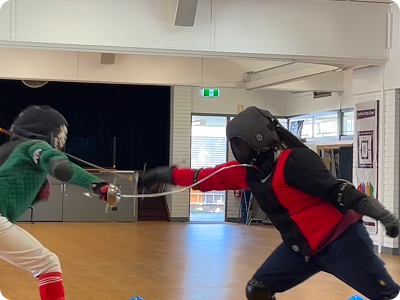 Two people sparring with swords