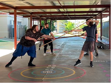A group of people sparring with swords at Swordwork